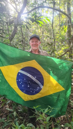 Chris holding a Brazillian flag at the South American Pole of Inaccessibility